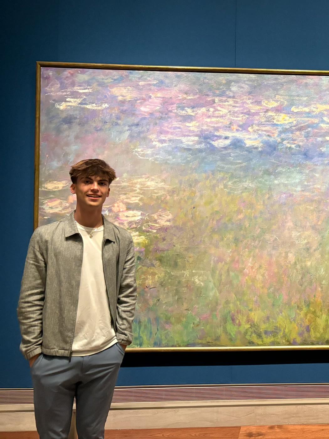 Lewis Suttle standing in front of a Monet water lilies painting